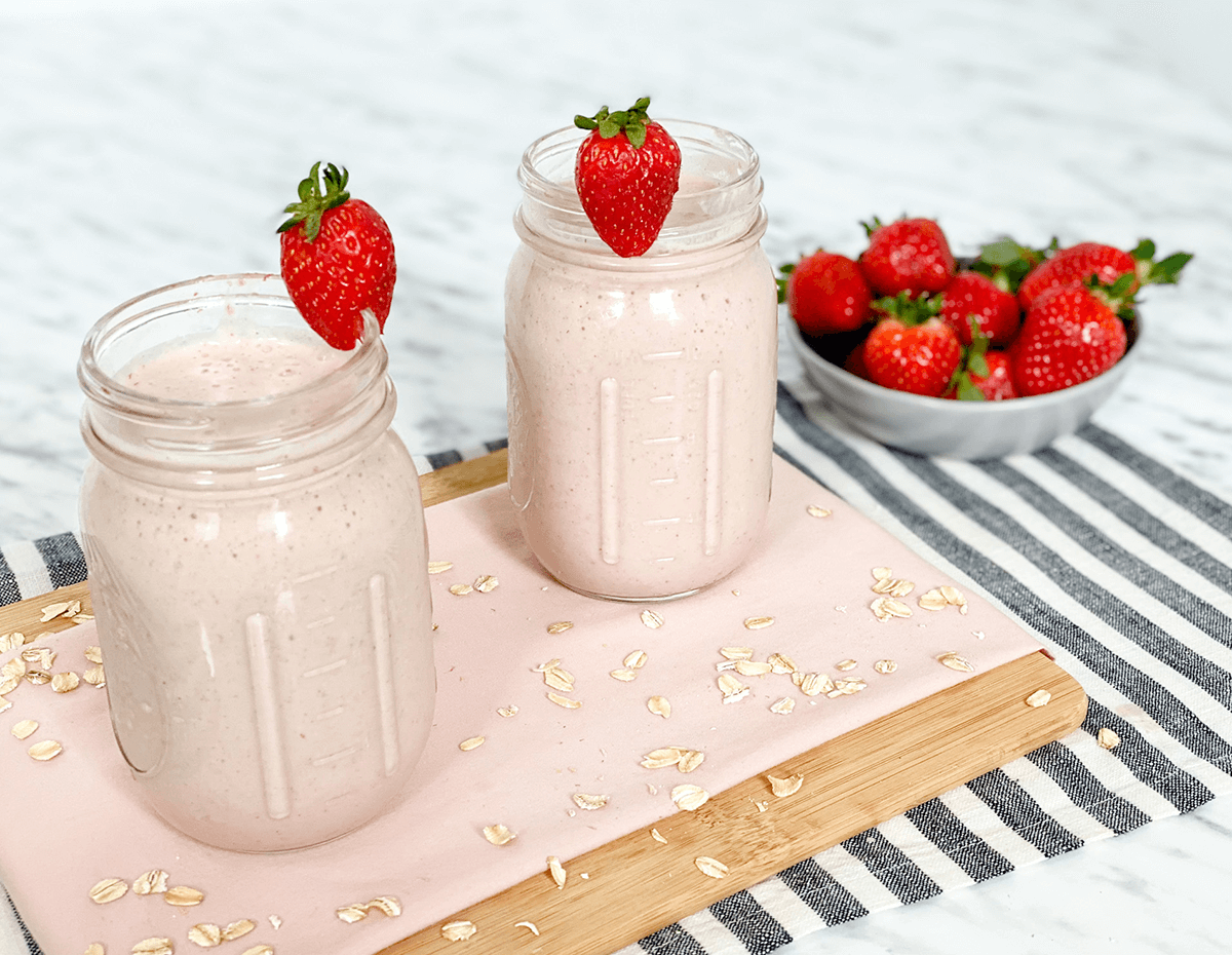Two mason jars full of oat almond butter strawberry smoothie
