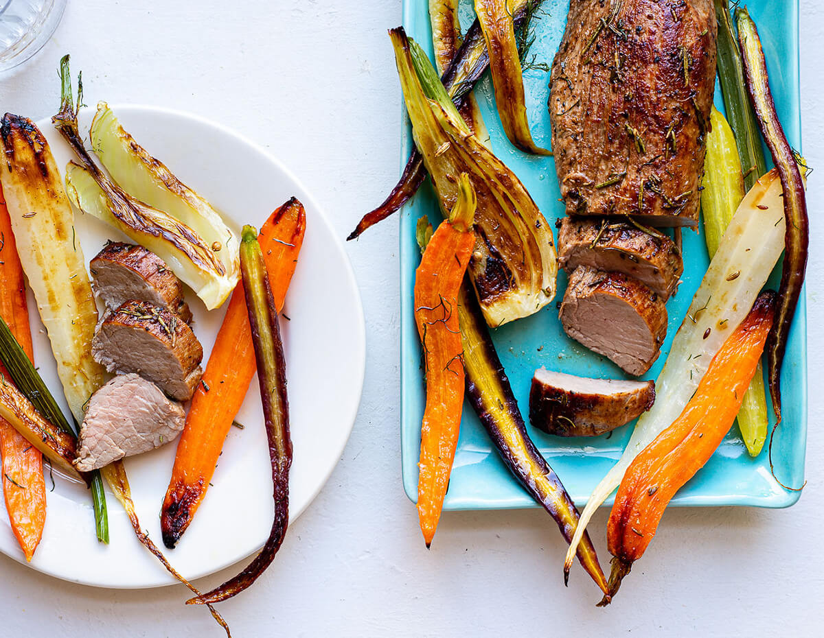 A platter and serving of balsamic and rosemary glazed pork tenderloin with roasted roots