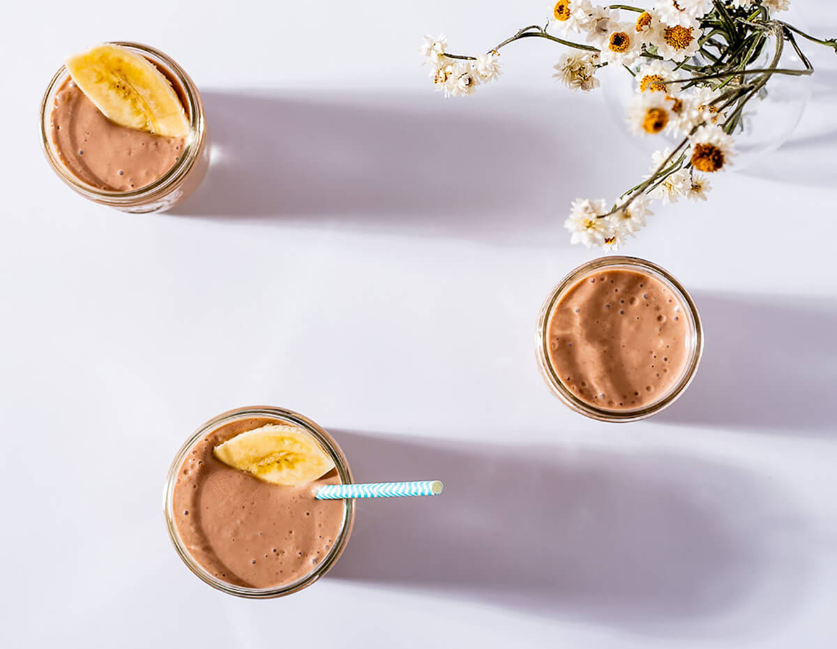 Top down view of a banana yogurt smoothie served in a mason jar