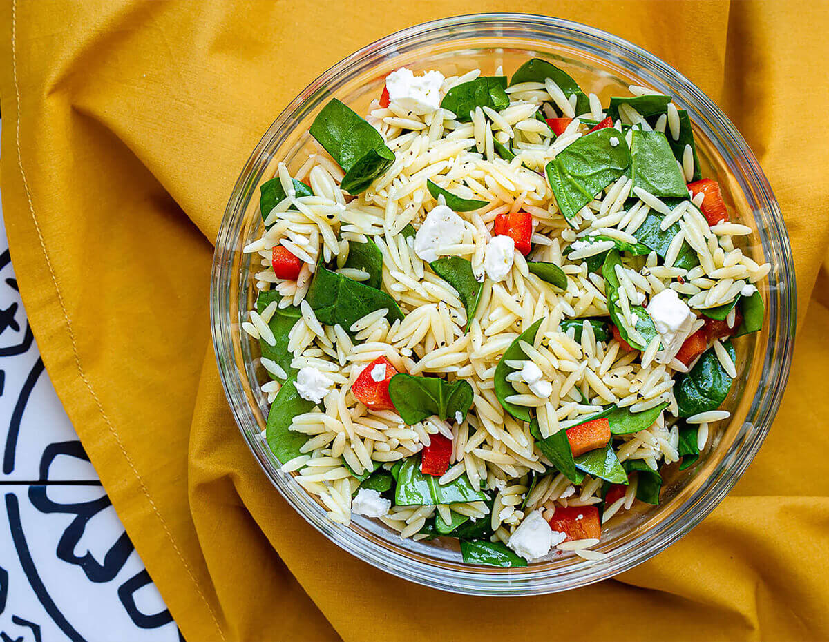 A bowl full of orzo spinach salad