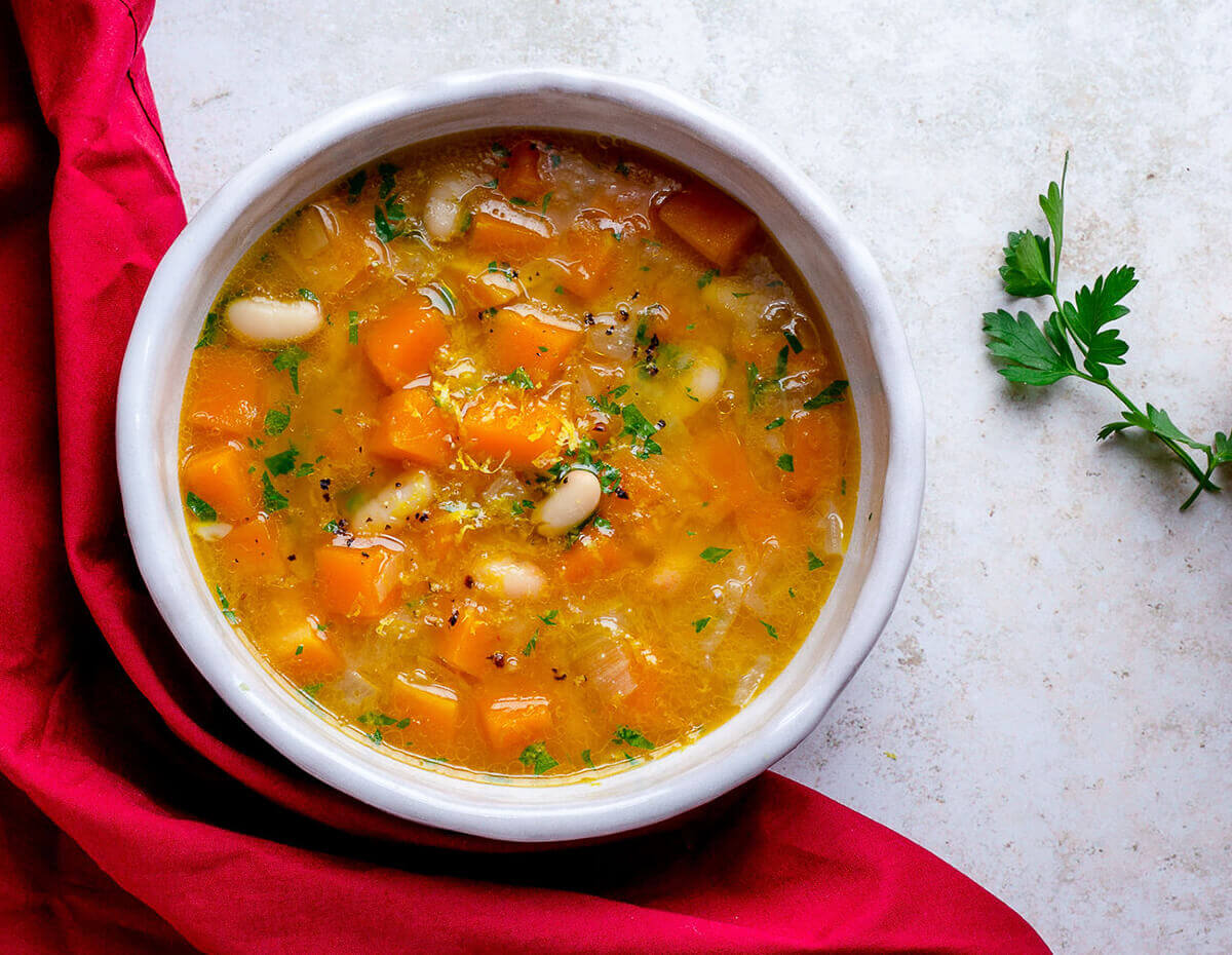 A hearty bowl of cannellini bean and butternut squash soup with lemon zest