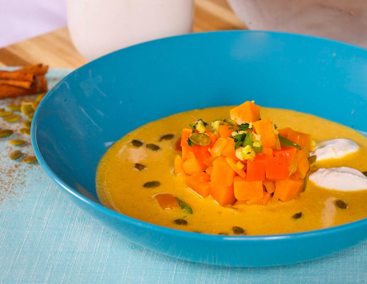 A blue bowl full of roasted pumpkin soup