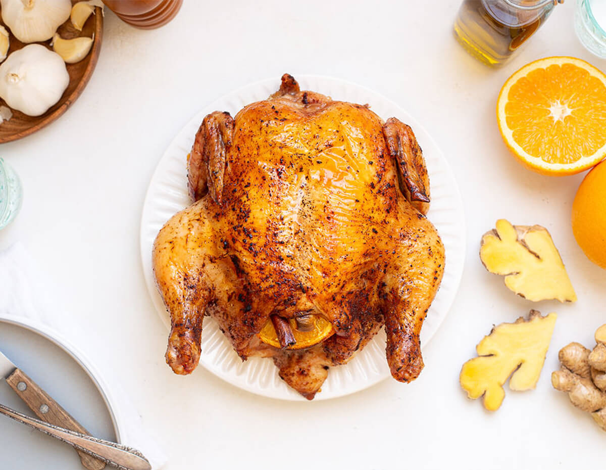 Whole roasted ginger orange chicken served on a plate