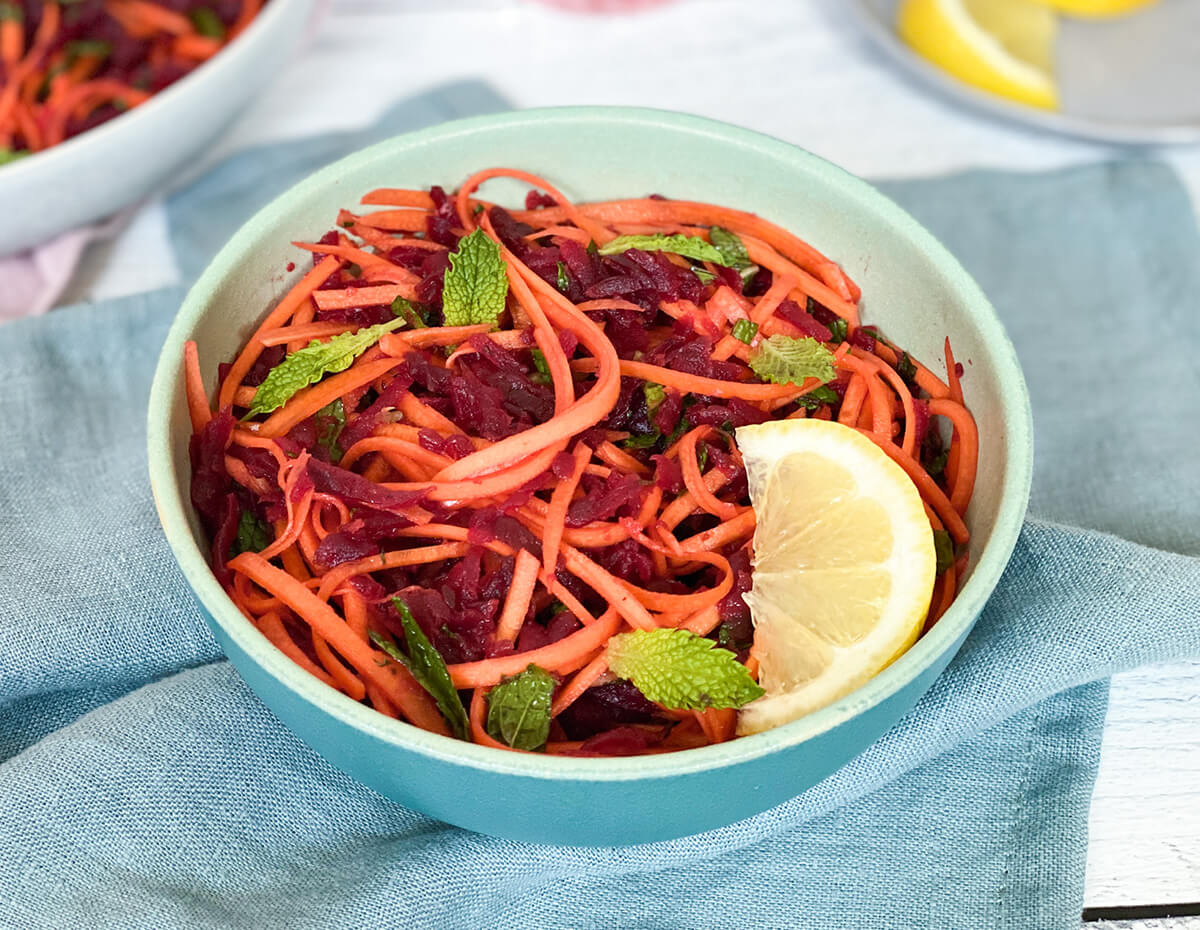 Shredded carrot and beat salad served in a blue bowl