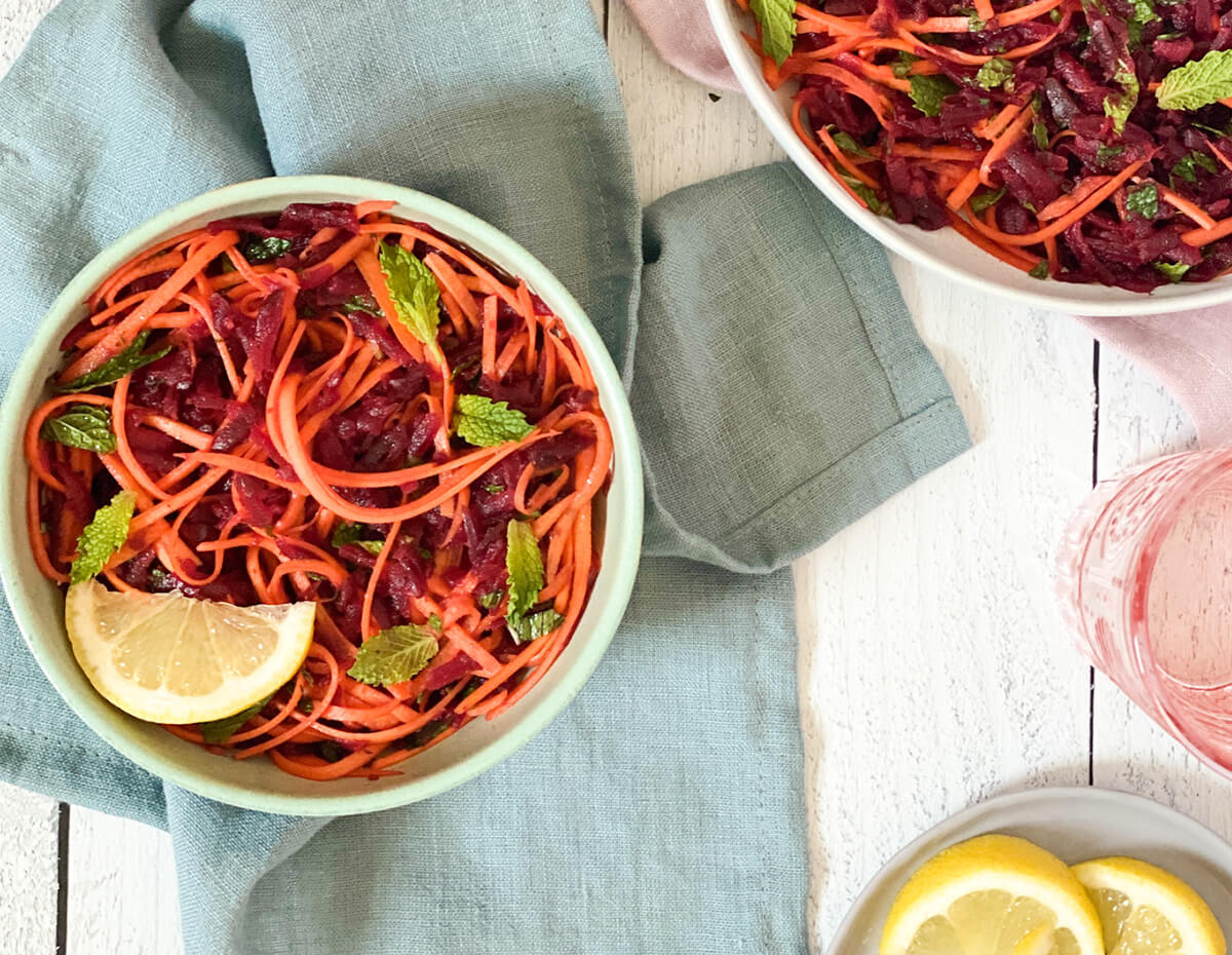 Shredded carrot and beat salad served in a blue bowl