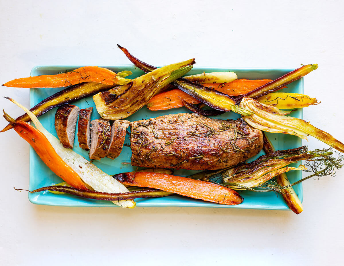 A platter of pork tenderloin with roasted roots